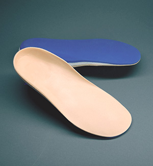 A pair of custom shoe insert orthotics. The top is tan and the bottom is blue.