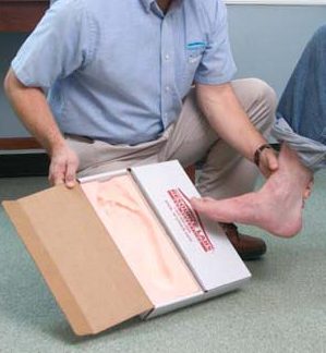 A pedorthist creates a an impression of a foot